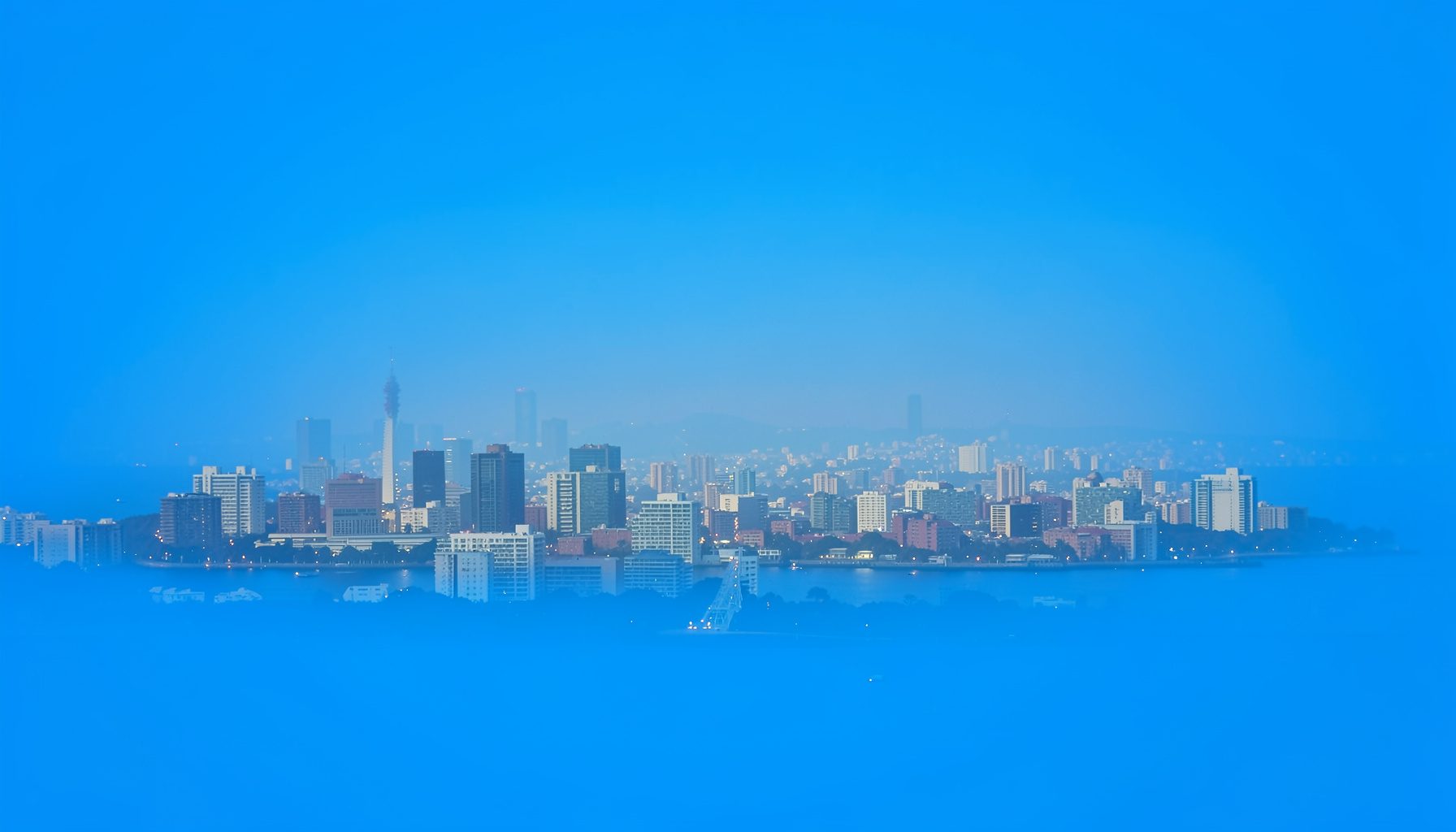 A photograph of a city skyline with visible haze, muted tones
